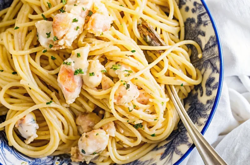 Creamy lobster pasta with spaghetti served in a decorative blue and white bowl