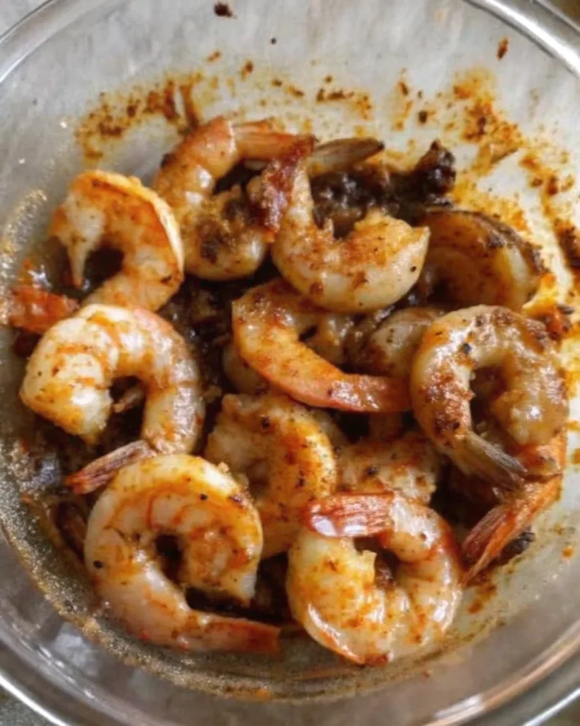 Margarita grilled shrimp served in a black bowl with lime wedges and cilantro garnish.