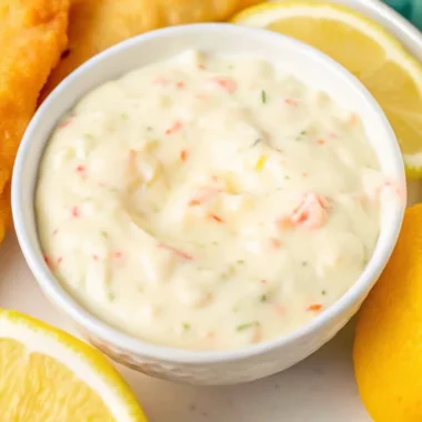 A bowl of creamy Red Lobster tartar sauce served with crispy fried fish and lemon wedges.