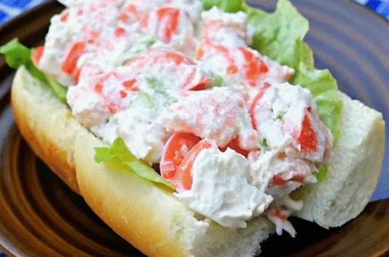 The best seafood salad recipe (Publix copycat) with imitation crab, shell pasta, peas, and creamy dressing in a white bowl.