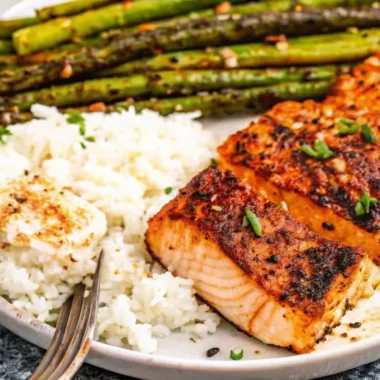 Cajun honey butter salmon fillets seared in cast iron skillet with golden glaze and fresh parsley garnish