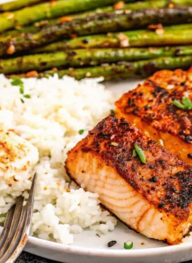 Cajun honey butter salmon fillets seared in cast iron skillet with golden glaze and fresh parsley garnish